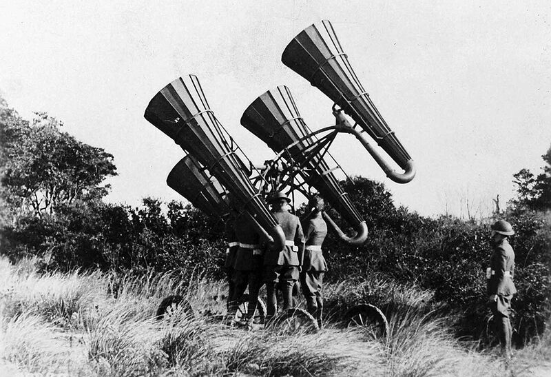 American troops using a newly-developed acoustic locator, mounted on a wheeled platform. The large horns amplified distant sounds, monitored through headphones worn by a crew member, who could direct the platform to move and pinpoint distant enemy aircraft. Development of passive acoustic location accelerated during World War I, later surpassed by the development of radar in the 1940s.