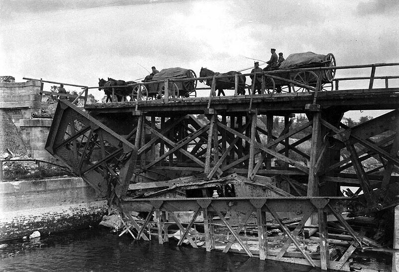 On the site where a steel bridge was destroyed, a wooden temporary bridge has been built in place. Note that an English tank which fell in the river when the former bridge was demolished now serves as part of the foundation for the new bridge over the Scheldt at Masnieres.
