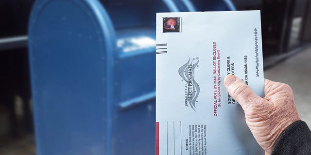 Person mailing absentee ballot for voting in an election by mail in Gualala, Calif., July 4, 2020.
