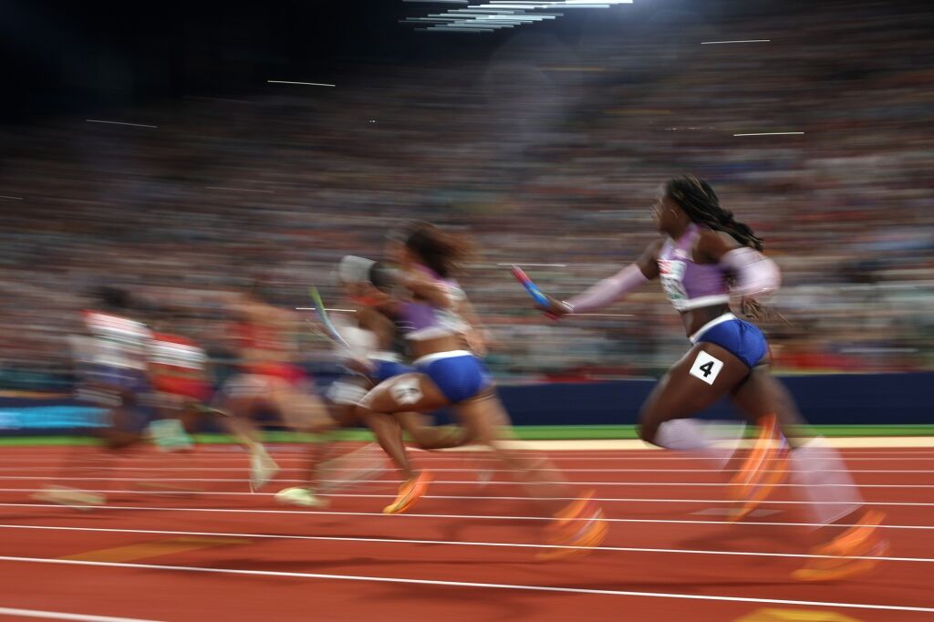 Imani Lansiquot takes the baton off of Asha Philip of Great Britain as they compete in the Women's 4 x 100m Relay.