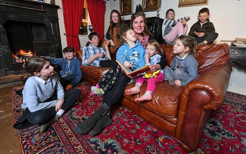 Amanda Owen reads to her children (left to right) Edith, 10, Miles, 13, Reuben, 15, Raven, 17, Clammy, three, Nancy, two, Violet, eight, Annas, five, and Sydney, six, on their farm in Yorkshire